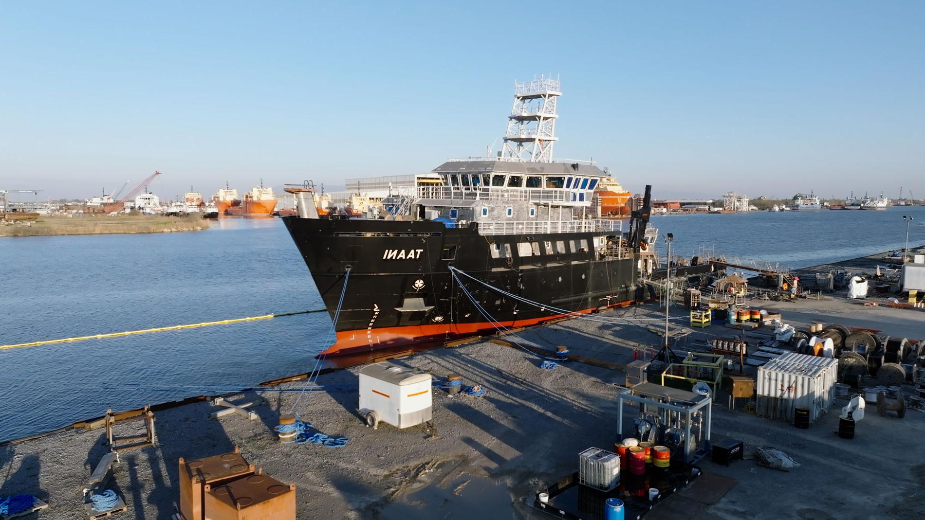 A massive ship rests at the dock, gently floating on the water's surface